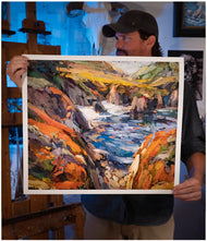 Artist Sean Diediker holding a print of his artwork Red Cliffs on Highway 1 in Big Sur California.